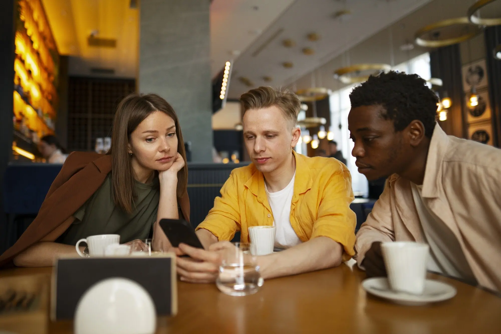 Eine Gruppe von Freunden schaut sich gemeinsam die Speisekarte in einem Restaurant an, praxisnah und nachvollziehbar.