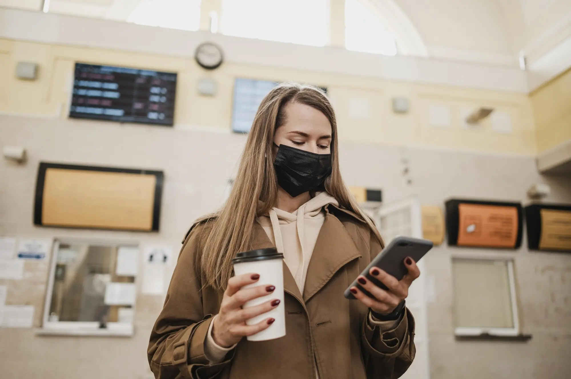 Niedriger Blickwinkel auf eine Frau, die im Inneren eines Bahnhofs wartet.